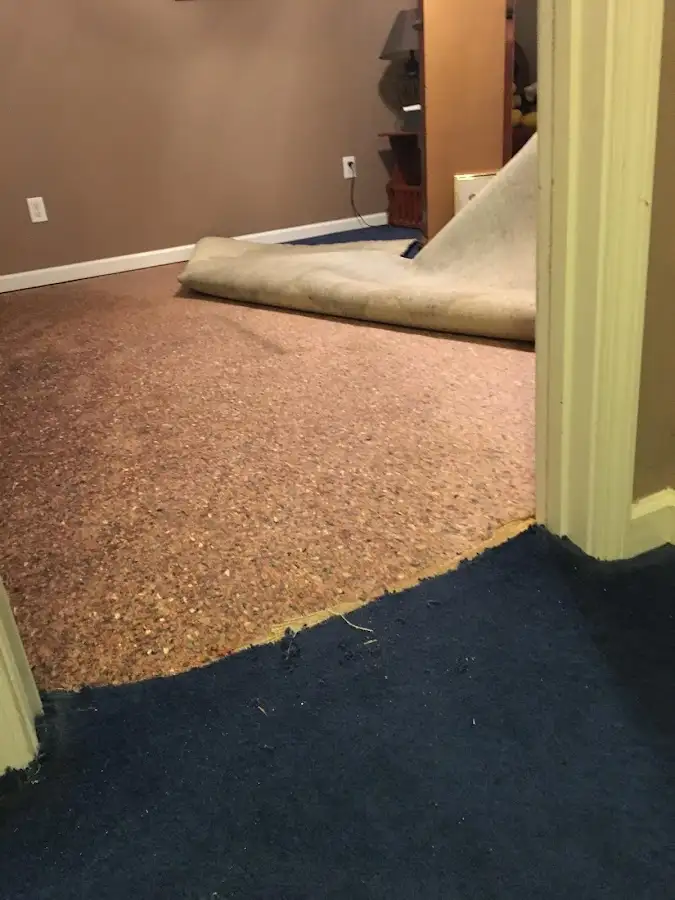 Carpet pad removal revealing water damage during Water Mitigation Services in Waggaman